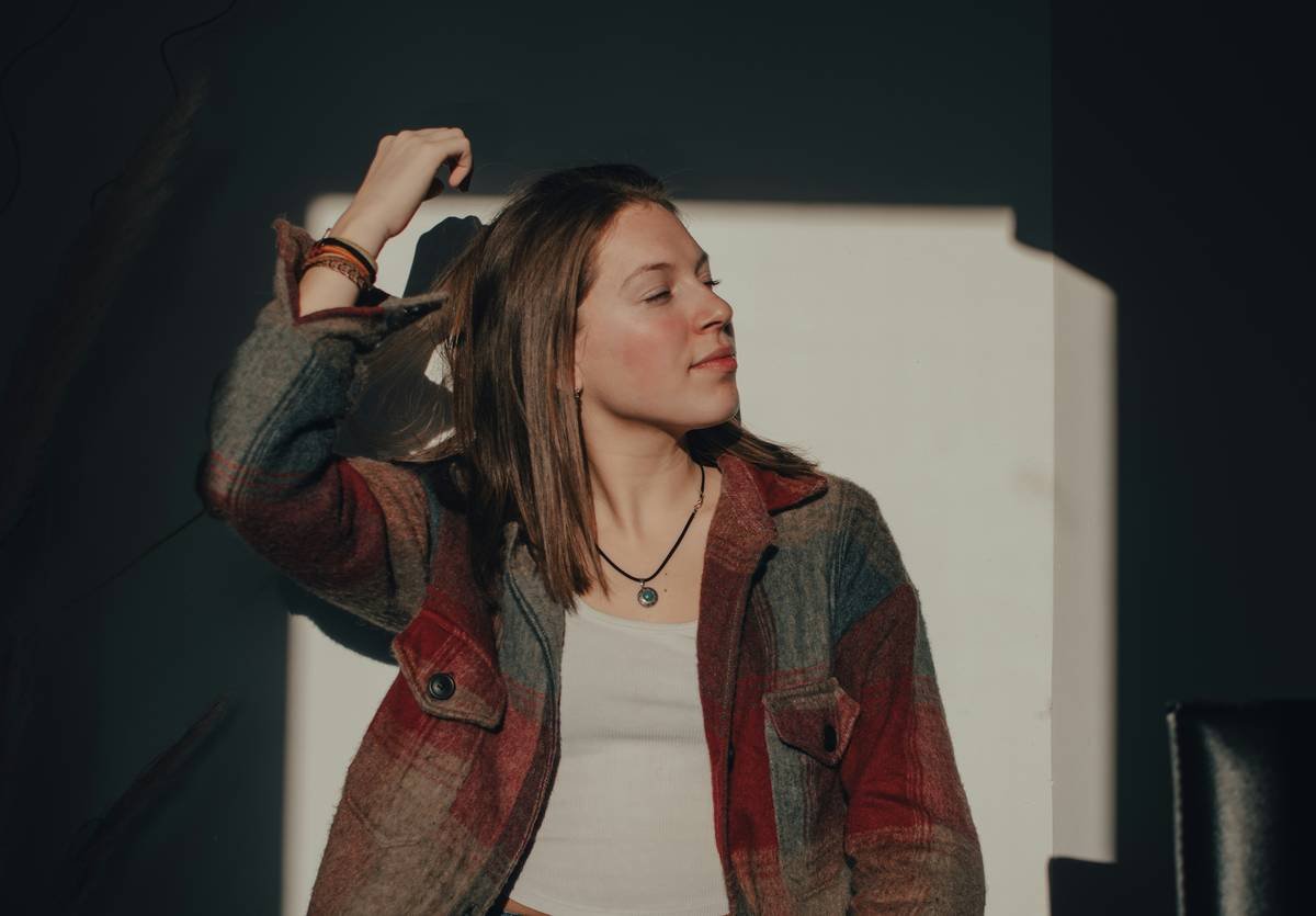 a woman standing in front of a white wall